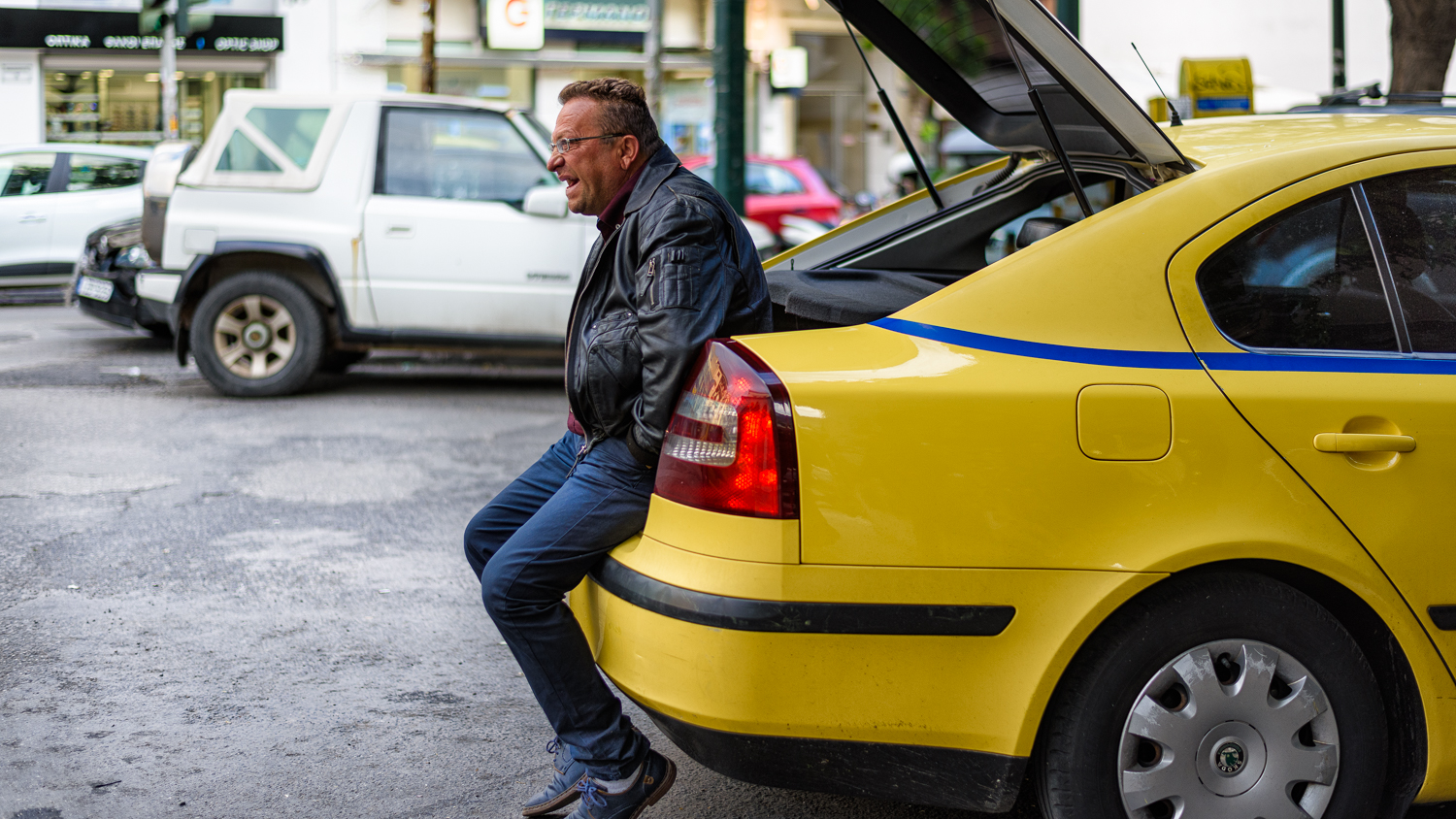 Taxichaufeur zit in kofferbak van zijn gele taxi